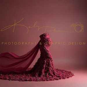 Puede incluir: Una persona embarazada lleva un vestido largo, fluido, de color burdeos hecho completamente de flores. El vestido tiene una capa de color burdeos transparente que ondea con el viento. El fondo es de color burdeos sólido.