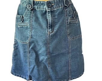 May include: A blue denim skirt with two front pockets and a button closure. The skirt has a straight fit and a slightly flared hem.