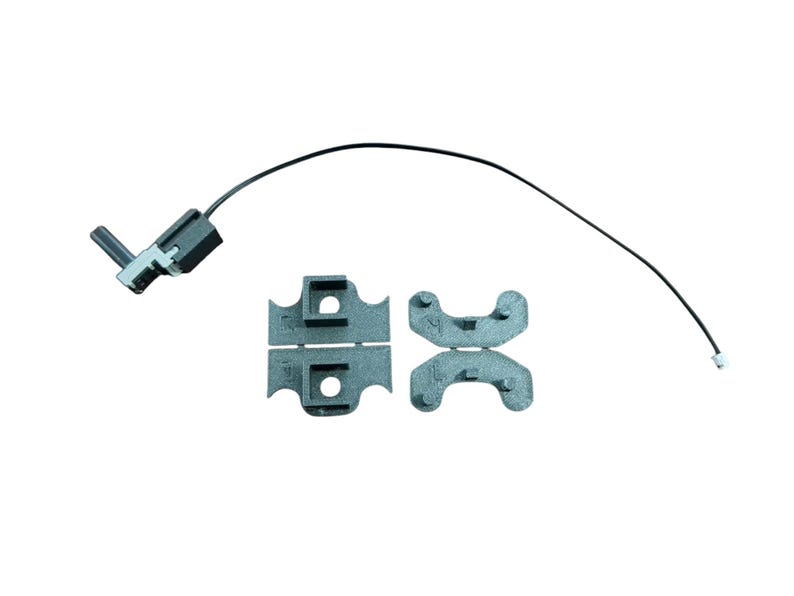 May include: A black switch with a wire and two black plastic pieces. The switch has a silver lever.