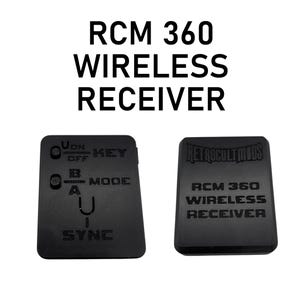 May include: Two black wireless receiver devices. The text "RCM 360 WIRELESS RECEIVER" is printed on the top of the image. One device has control labels, and the other has the "RETROCULTMODS" logo and product information.