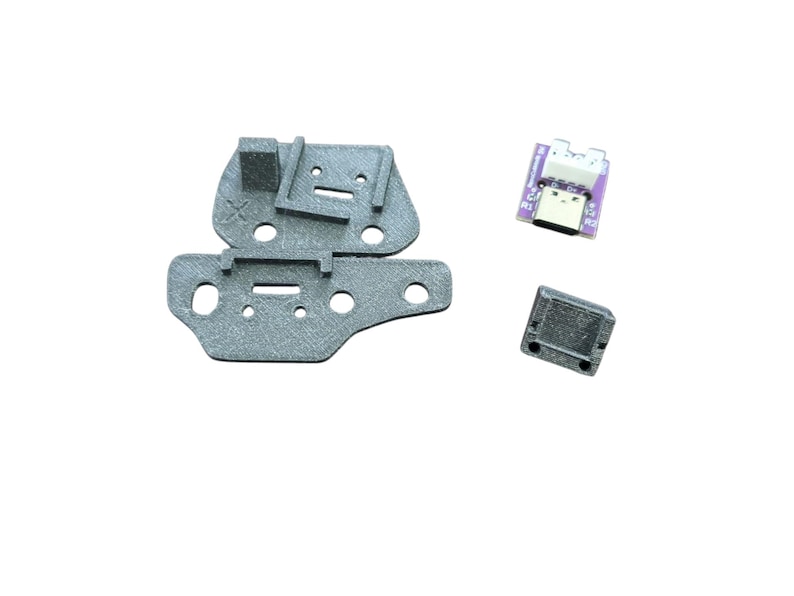May include: A set of three 3D printed parts for a Raspberry Pi project. The parts are gray and include a base, a connector, and a small rectangular piece.