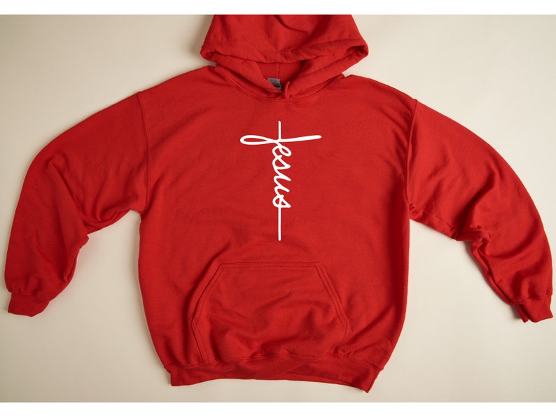 May include: Red hooded sweatshirt with a white cross and the word "Jesus" written vertically on it.