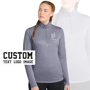 May include: A heather gray long-sleeve shirt with a mock neck and a quarter-zip closure. The shirt has a white logo on the chest that says "COMPANY EST. 2019".