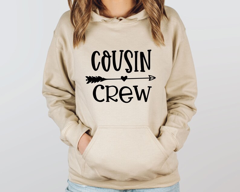 May include: A beige hoodie with a black graphic that says "COUSIN CREW" with an arrow and a heart.