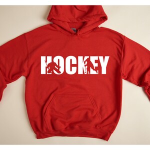 May include: Red hooded sweatshirt with white text that says "HOCKEY" with a hockey player silhouette inside each letter.