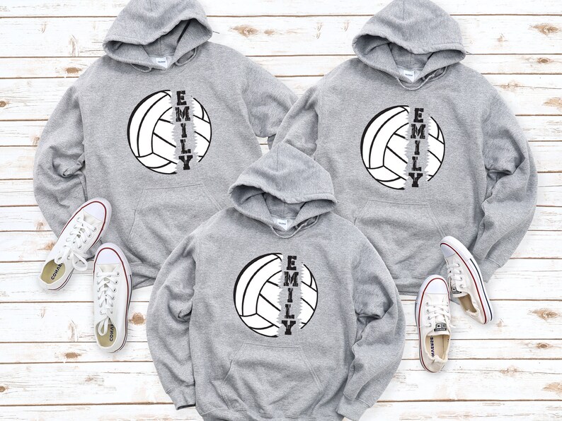 May include: Three gray hooded sweatshirts with a volleyball graphic and the name "Emily" printed vertically down the side of the volleyball.