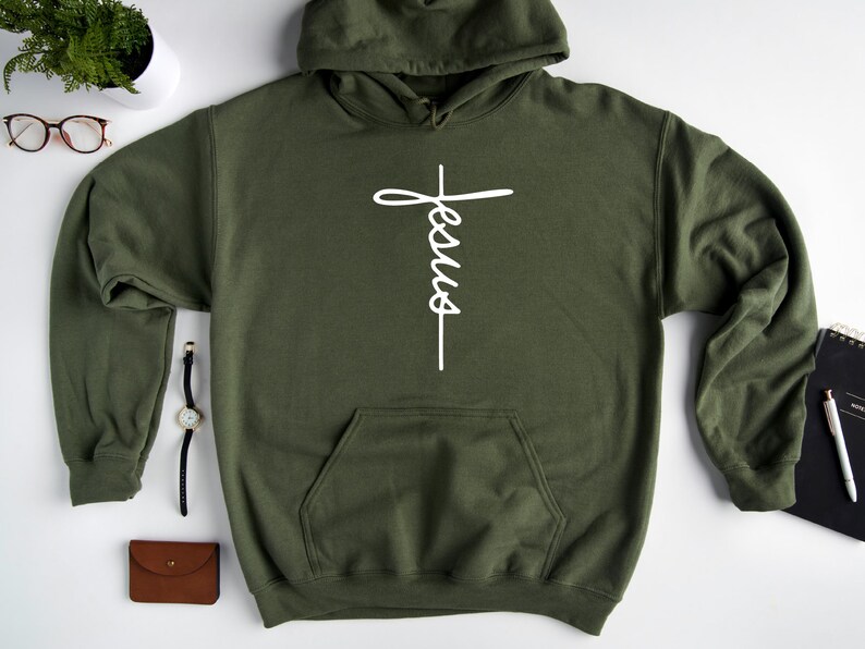 May include: A green hooded sweatshirt with a white cross and the word "Jesus" written vertically on it.