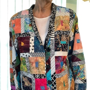 May include: A colorful patchwork jacket with a black background and a variety of fabrics, including floral, geometric, and abstract patterns.