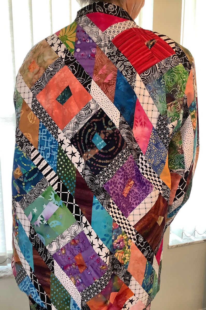May include: A colorful patchwork jacket with a diamond pattern. The jacket is made of various fabrics in shades of pink, blue, green, purple, and brown. The fabric is sewn together in a geometric pattern.