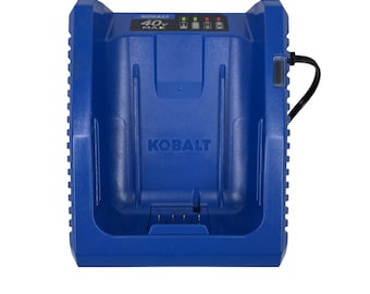 Pode incluir: Um carregador de bateria azul Kobalt 40V MAX com caixa de plástico moldado. A unidade possui um compartimento de carregamento central com contatos elétricos na base, luzes indicadoras de status e um cabo de alimentação preto à direita.