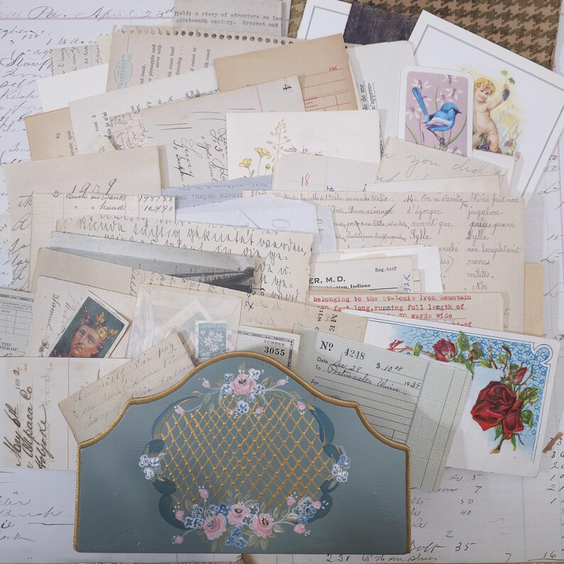 Pode incluir: Uma cole&ccedil;&atilde;o de ef&ecirc;meras vintage, incluindo cartas manuscritas, cart&otilde;es e recibos. Um suporte decorativo azul-petr&oacute;leo com um design floral e detalhes dourados est&aacute; na parte inferior. V&aacute;rios selos e ilustra&ccedil;&otilde;es est&atilde;o espalhados.