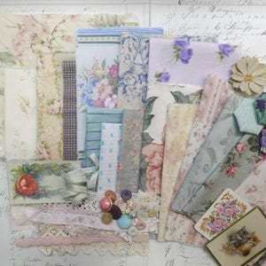 May include: A collection of vintage fabric scraps in various floral patterns and colors, including pink, blue, and cream. The assortment includes lace trim, buttons, and a small floral card, creating a nostalgic, romantic aesthetic. Ideal for crafting and scrapbooking projects.