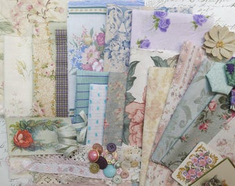 May include: A collection of vintage fabric scraps in various floral patterns and colors, including pink, blue, and cream. The assortment includes lace trim, buttons, and a small floral card, creating a nostalgic, romantic aesthetic. Ideal for crafting and scrapbooking projects.
