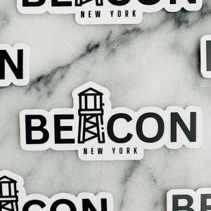 May include: Black and white sticker with a lighthouse graphic and the text "Beacon New York".