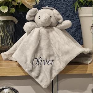 May include: A gray plush elephant security blanket with the name "Oliver" embroidered on it.