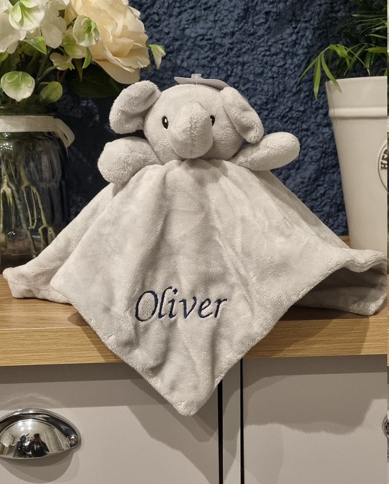 May include: A gray plush elephant security blanket with the name "Oliver" embroidered on it.