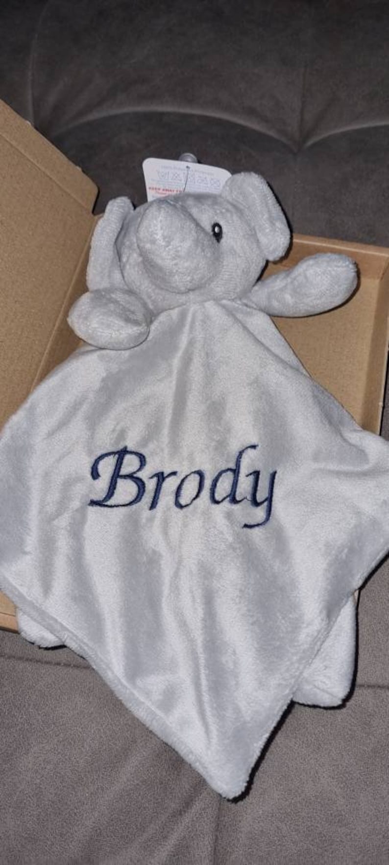 May include: A gray plush elephant security blanket with the name "Brody" embroidered in blue thread.