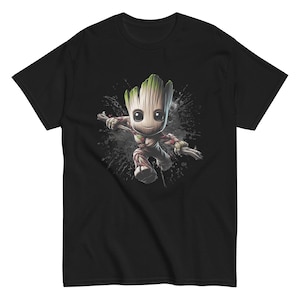 May include: Black t-shirt with a cartoon illustration of Groot from Guardians of the Galaxy. The character has a wooden body, green leaves, and a friendly expression. The design includes a grey splatter effect.