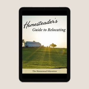 May include: A digital tablet displaying a guide for homesteaders on relocating. The cover features a white farmhouse with a green field and a sunset in the background. The text on the cover reads "Homesteader's Guide to Relocating" and "The Homestead Education".