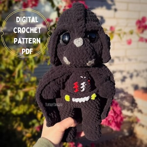 May include: A black crochet plush toy with large, round eyes and a detailed design. The toy has a distinctive helmet shape and a chest emblem with red, white, and yellow accents. The text "DIGITAL CROCHET PATTERN PDF" is in a circle in the upper left.