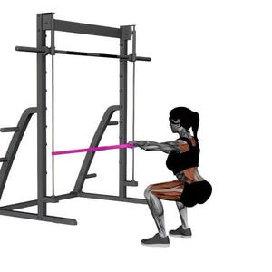 Op de afbeelding: Een persoon voert een squat-oefening uit met een Smith-machine en een weerstandsband. De machine is zwart en de band is roze. De persoon draagt zwarte sportkleding. De achtergrond is wit.