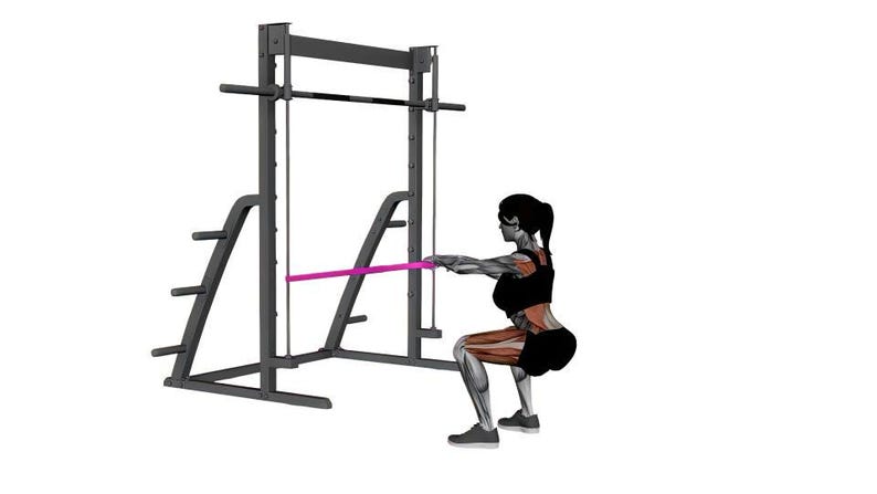 Op de afbeelding: Een persoon voert een squat-oefening uit met een Smith-machine en een weerstandsband. De machine is zwart en de band is roze. De persoon draagt zwarte sportkleding. De achtergrond is wit.