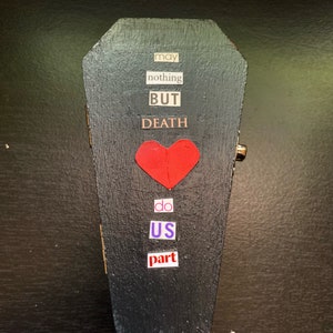 May include: A black coffin-shaped box with a red heart and the words "may nothing but DEATH do us part" in white letters.