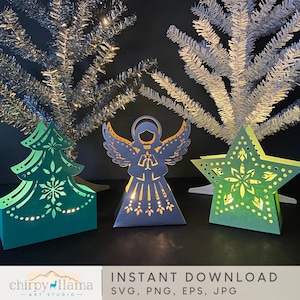 Pu&ograve; includere: Tre decorazioni natalizie di carta illuminate: un albero verde, un angelo argentato e una stella verde. Le decorazioni sono illuminate dall'interno, creando un bagliore caldo. Le decorazioni sono su uno sfondo scuro.
