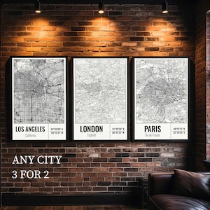 May include: Three framed city map prints, featuring Los Angeles, London, and Paris, displayed on a brick wall. Each map is in black and white, with city names and coordinates. The text "ANY CITY 3 FOR 2" is below the prints.