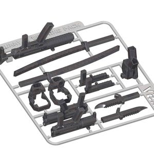 May include: A sprue of dark gray plastic model kit weapons. Includes two rifles, two swords, two knives, and other accessories. The sprue is labeled "WEAPONS PACK" and "V2.0".