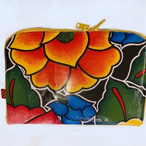 May include: A colorful zippered pouch with a floral design. The pouch features a black background with red, yellow, blue, and green flowers.