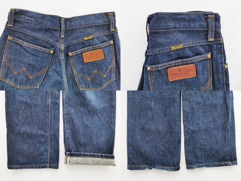 Op de afbeelding: Donkerblauwe Wrangler jeans van denim. De jeans hebben een klassiek ontwerp met vijf zakken, een bruine leren patch met het Wrangler-logo en een rechte pijp. De jeans worden vanuit meerdere hoeken getoond, inclusief de achterzakken en de opgerolde zoom.
