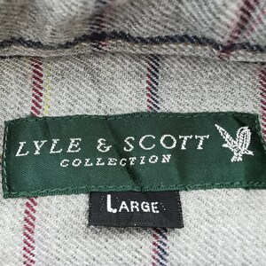 以下が含まれることがあります： グレーのチェック柄の生地のクローズアップ。緑色のラベルには「LYLE & SCOTT COLLECTION」と書かれています。ラベルの下には「LARGE」と書かれた黒いタグがあります。生地には赤、黄、青のストライプがあります。