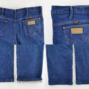 Puede incluir: Vaqueros de mezclilla azul oscuro con el logo de Wrangler en el bolsillo trasero y un parche de cuero marr&oacute;n. Los vaqueros tienen un dise&ntilde;o cl&aacute;sico de cinco bolsillos con pernera recta y dobladillo doblado. Los vaqueros son de lavado medio.