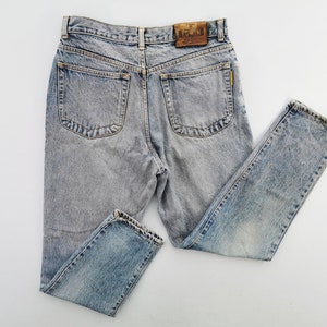 Op de afbeelding: Lichtblauwe acid wash jeans met een klassiek vijf-zakken ontwerp. De jeans hebben een rechte pijp en een leren patch met de merknaam "EDWIN" op de rug. De denim heeft een vervaagde, versleten uitstraling.