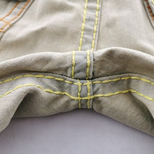 May include: A white ceramic mug with a black handle and the text "But first, coffee" in a black, handwritten-style font. The mug is on a white surface.