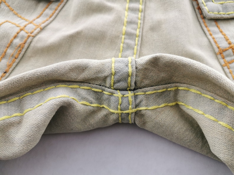 May include: A white ceramic mug with a black handle and the text "But first, coffee" in a black, handwritten-style font. The mug is on a white surface.