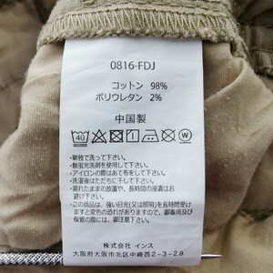 May include: Close-up of a clothing tag with the code 0816-FDJ. The tag indicates the fabric is 98% cotton and 2% polyurethane. Washing instructions are also printed on the tag.