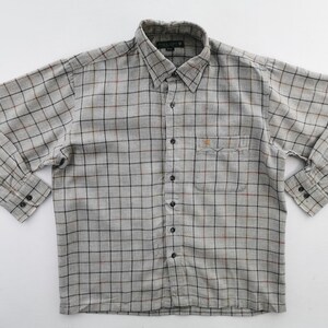 以下が含まれることがあります： 長袖のグレーのチェック柄シャツ。ボタンダウンカラー、胸ポケット、黒いボタンが付いています。チェック柄は黒、赤、茶色の線で構成されています。シャツは白い背景に平らに置かれています。