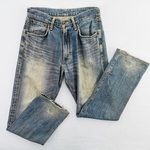 May include: Faded blue denim jeans with a classic five-pocket design. The jeans show signs of wear and tear, with distressed areas and a light wash effect. The jeans are laid flat on a white surface, showcasing their vintage style.