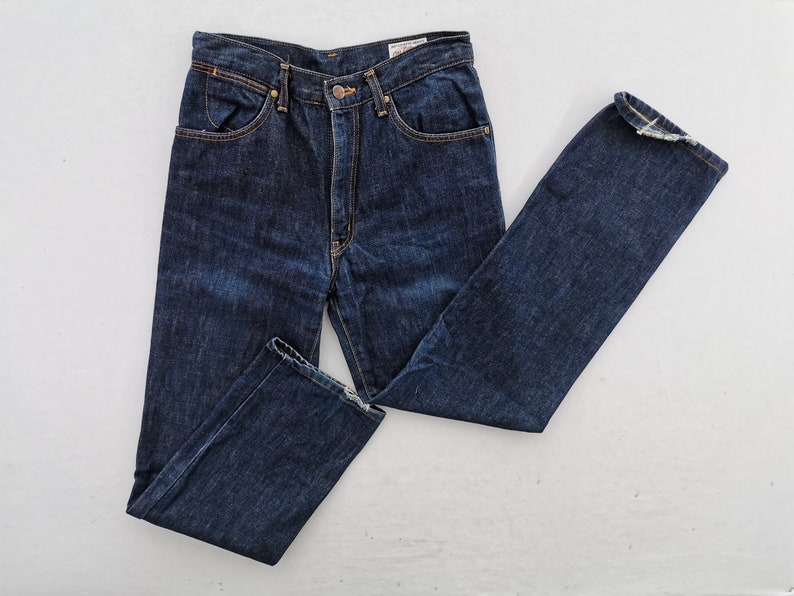 Op de afbeelding: Donkerblauwe denim jeans met een klassiek ontwerp met vijf zakken. De jeans hebben een knoop- en ritssluiting, met een rechte pijp. De denim heeft een licht vervaagd uiterlijk en de stiksels zijn in een contrasterende goudkleur.
