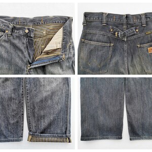 Peut inclure: Gros plans d'un jean en denim bleu d&eacute;lav&eacute;. Le jean pr&eacute;sente une fermeture boutonn&eacute;e et zipp&eacute;e, une conception classique &agrave; cinq poches et un patch en cuir avec le nom de la marque. Les revers sont retrouss&eacute;s, r&eacute;v&eacute;lant une doublure ray&eacute;e.