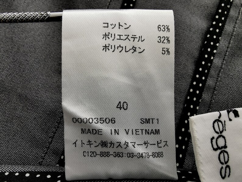 May include: Close-up of a white clothing tag with Japanese text and percentages for cotton, polyester, and polyurethane. The tag also includes the size 40, the text "MADE IN VIETNAM", and a customer service phone number.