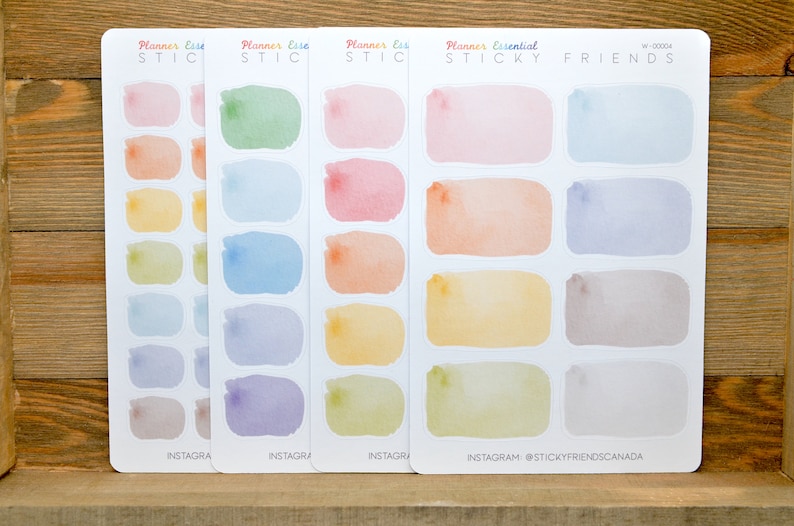May include: Four sheets of colorful watercolor planner stickers with rounded rectangular shapes. The stickers are in shades of pink, blue, yellow, and green. The sheets are labeled "Planner Esse STICKY" and "Planner Essential STICKY FRIENDS".
