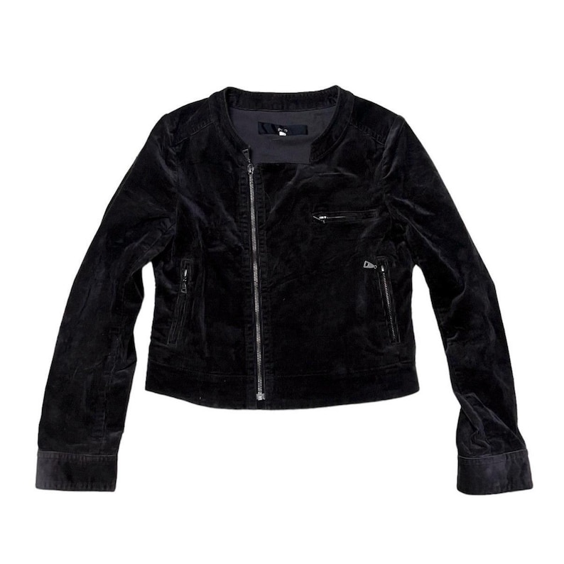 May include: A black velvet jacket with a round collar and a silver zip. The jacket has two zipped front pockets and long sleeves. The jacket is a cropped style.