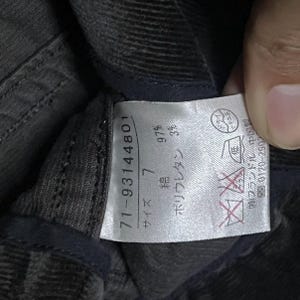 May include: A close-up shot of a clothing label with Japanese text and numbers. The label is white with black text and displays the numbers "71-93144801" and "7". The fabric composition is 97% cotton and 3% polyurethane.