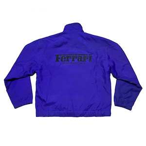 May include: A purple jacket with a black Ferrari logo and the text "Sponsorizzata dalla" on the back.