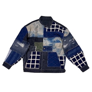 Könnte beinhalten: Patchwork-Jeansjacke mit Kragen und Knopfverschluss. Die Jacke hat eine Vielzahl von blauen Denim-Patches, darunter Quadrate, Streifen und Steppmuster. Sie hat zwei Vordertaschen und einen dunkelblauen Kragen und Manschetten.