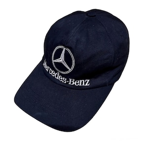 May include: A black baseball cap with a white embroidered Mercedes-Benz logo and text.