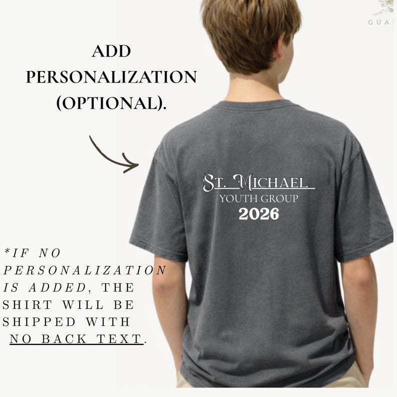 May include: A gray t-shirt with the text "St. Michael Youth Group 2026" printed on the back in white. The shirt also has text that says "Add Personalization (Optional)" and "If no personalization is added, the shirt will be shipped with no back text."